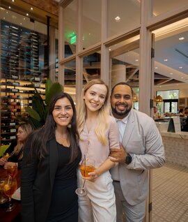 people posing for a photo smiling at a happy hour